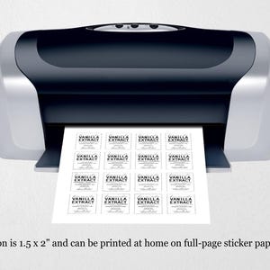 May include: A black and silver desktop printer outputting a sheet of white paper with sixteen rectangular labels printed in black ink. Each label features the text Vanilla Extract in a bold serif font with smaller decorative script text below.