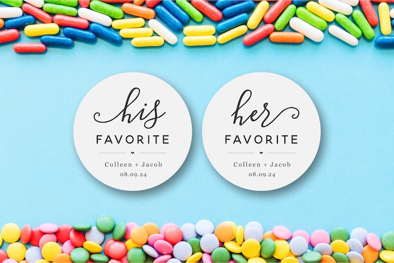 Op de afbeelding: Twee witte ronde stickers met zwarte tekst. De linker sticker zegt "zijn favoriet" met de namen "Colleen + Jacob" en de datum "08.09.24" eronder. De rechter sticker zegt "haar favoriet" met dezelfde namen en datum eronder. De stickers zijn op een lichtblauwe achtergrond met kleurrijke snoepjes erboven en eronder.