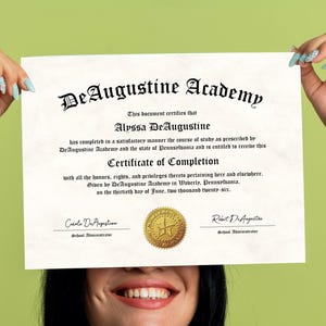 May include: A certificate of completion from DeAugustine Academy, with the name Alyssa DeAugustine. The document has a gold seal and is held up by a person with light blue nail polish. The certificate is dated June 30, 2026.