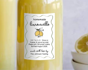 May include: A clear glass bottle filled with yellow liquid featuring a white rectangular label with a wavy green border. The label reads homemade limoncello, details: store in freezer & serve ice cold. Made with 100 proof vodka. Bottled August 2026. Made with love by The Johnson Family.