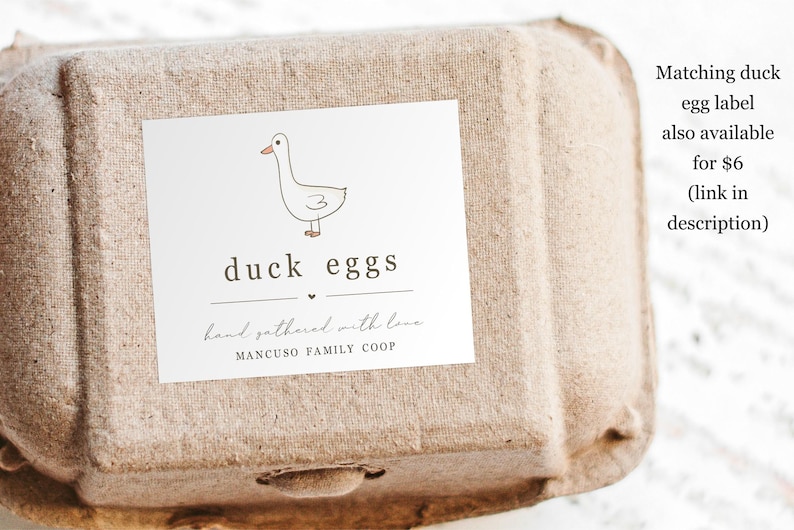 May include: A white cardboard egg carton with a label that says "duck eggs" and has a hand-drawn illustration of a duck. The label also says "hand gathered with love" and "MANCUSO FAMILY COOP".
