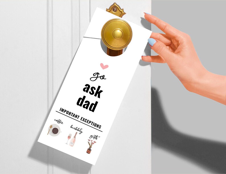 Puede incluir: Colgador de puerta blanco con el texto "go ask dad" y un coraz&oacute;n rosa. Debajo del texto, "IMPORTANT EXCEPTIONS" con tres iconos: una taza de caf&eacute;, una copa de champ&aacute;n y un ramo de flores.