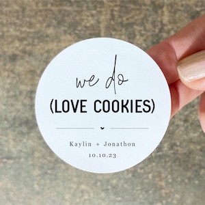 May include: White round sticker with the text "we do (LOVE COOKIES)" and the names "Kaylin + Jonathon" and the date "10.10.23" printed on it.