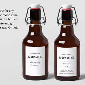 May include: Two brown glass bottles with swing top lids. The bottles have white labels that say "homemade moonshine" and list different flavours: "strawberry lemonade" and "strawberry pie". The label on the right bottle also includes the text "Made with love by The Tromar Family Bottled: November 2024".