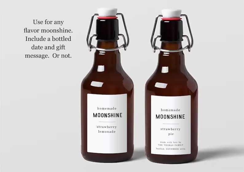 May include: Two brown glass bottles with swing top lids. The bottles have white labels that say "homemade moonshine" and list different flavours: "strawberry lemonade" and "strawberry pie". The label on the right bottle also includes the text "Made with love by The Tromar Family Bottled: November 2024".