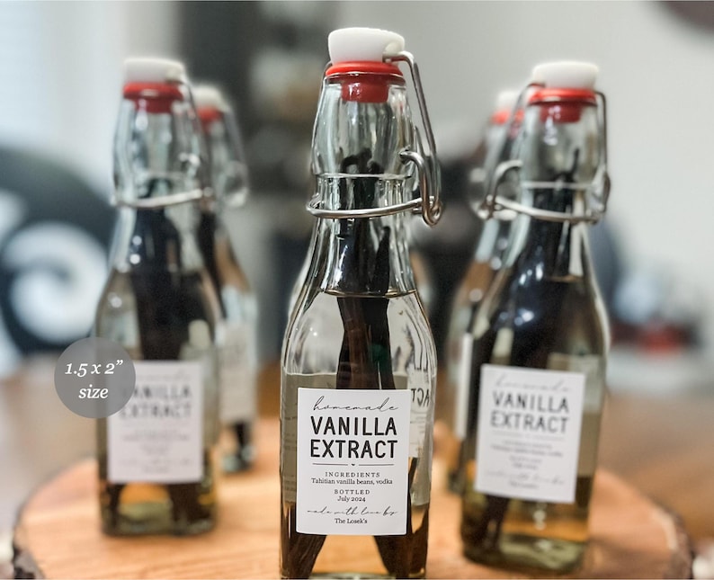May include: Clear glass bottles with swing-top lids and red rubber seals, each containing dark vanilla beans submerged in liquid. A white rectangular label measuring 3.81 x 5.08 cm reads Homemade VANILLA EXTRACT, INGREDIENTS Tahitian vanilla beans, vodka, BOTTLED July 2024, made with love by The Loack's.