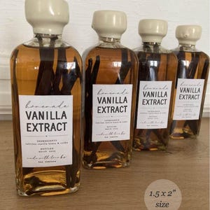 May include: Four clear glass bottles filled with amber liquid and dark vanilla beans, each topped with a cream-coloured cap. A white rectangular label on each bottle reads "homemade VANILLA EXTRACT" with additional text. A circular graphic indicates 3.8 x 5.1 cm size.