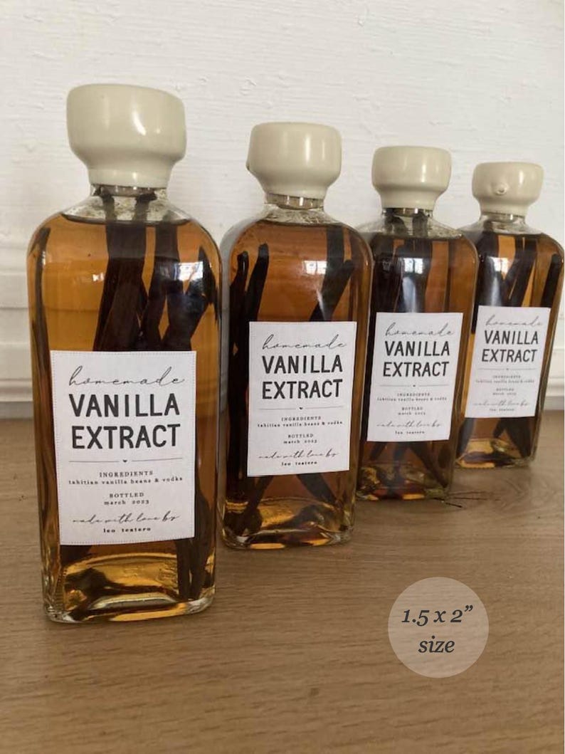 May include: Four clear glass bottles filled with amber liquid and dark vanilla beans, each topped with a cream-coloured cap. A white rectangular label on each bottle reads "homemade VANILLA EXTRACT" with additional text. A circular graphic indicates 3.8 x 5.1 cm size.