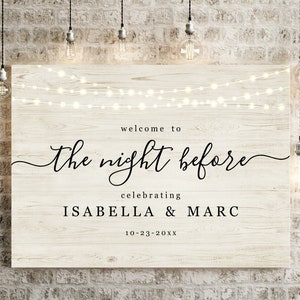 May include: A rustic wooden sign with string lights hanging above the text "Welcome to the night before celebrating Isabella & Marc 10-23-20XX".