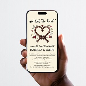 May include: A smartphone displaying a wedding invitation with the text we tied the knot, Isabella & Jacob, and event details. The design features a brown rope tied into a heart shape, surrounded by small red hearts and yellow stars on a cream background.