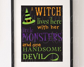 May include: A black framed print with a green witch hat and the text "A witch lives here with her little monsters and one handsome devil" in orange, green, purple and white text.