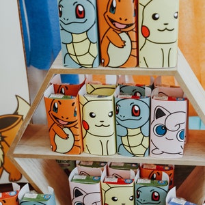 May include: A set of colourful juice boxes featuring various Pokemon characters. The boxes are displayed on a hexagonal wooden shelf.