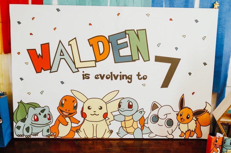 May include: A white sign with the text "Walden is evolving to 7" in colourful letters. The sign features cartoon images of Pokemon characters, including Bulbasaur, Charmander, Pikachu, Squirtle, Jigglypuff, and Eevee.