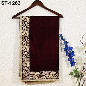 May include: A burgundy velvet shawl with intricate gold embroidery along the borders, featuring paisley and floral designs. The shawl is hanging on a wooden hanger. The text "ST-1263" is visible in the top left corner.