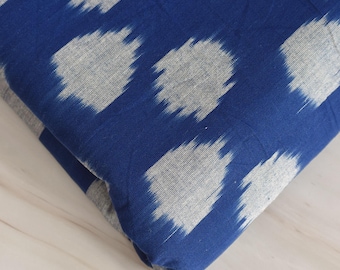 May include: Blue fabric with a white ikat pattern. The fabric is folded and the pattern is visible on both sides.