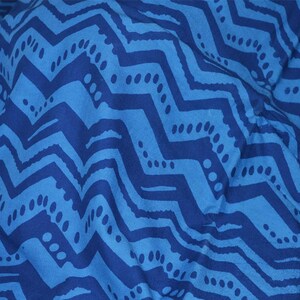 May include: Blue and dark blue fabric with a chevron pattern. The fabric has a subtle texture and a slightly faded look.