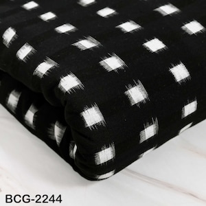 Pode incluir: Tecido preto com um padrão repetitivo de quadrados brancos ligeiramente desfocados. O tecido está dobrado, mostrando a textura e profundidade do material. O texto "BCG-2244" é visível na parte inferior.