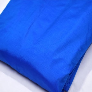 Pode incluir: Uma amostra de tecido azul brilhante. O tecido é liso e tem um leve brilho.