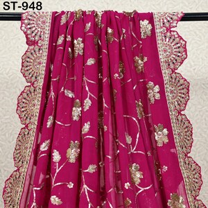 Puede incluir: Una vibrante tela fucsia con bordados florales dorados y detalles de lentejuelas. El borde presenta un ribete dorado festoneado con intrincados detalles de espejo. La tela est&aacute; drapeada, mostrando su textura fluida. El texto "ST-948" es visible.