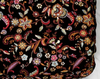 Puede incluir: Tela de terciopelo negro con un patrón de bordado floral en tonos de rojo, rosa, azul y dorado. La tela está adornada con lentejuelas y cuentas.