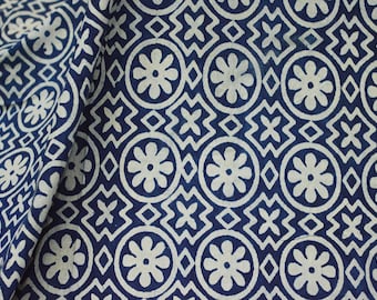 Pode incluir: Um tecido azul e branco com um padrão repetitivo de flores e formas geométricas.