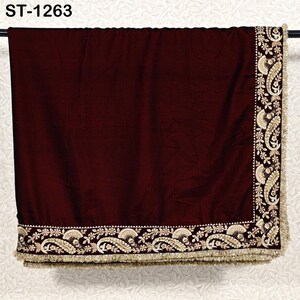 May include: A burgundy velvet shawl with intricate gold embroidery along the edges. The embroidery features paisley and floral designs, and the shawl has a gold fringe. The text "ST-1263" is visible in the upper left corner.
