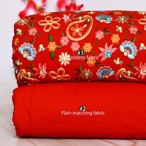 May include: Two pieces of red fabric. The top piece has a floral embroidery pattern with paisley shapes in shades of pink, blue, green, and yellow. The bottom piece is plain red. The text "#1 Embroidery fabric" is on the top piece and "#2 Plain matching fabric" is on the bottom piece.