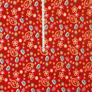 May include: Red fabric with a paisley and floral pattern. The fabric features a repeating pattern of small blue, pink, and orange flowers, along with paisley shapes in a light blue and white color scheme.