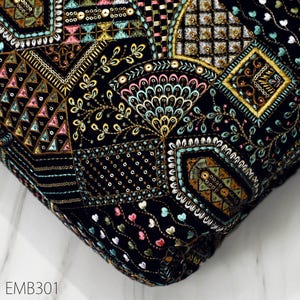 May include: Black fabric with intricate embroidery in gold, teal, pink, and white. The design features geometric patterns, floral motifs, and peacock feathers.