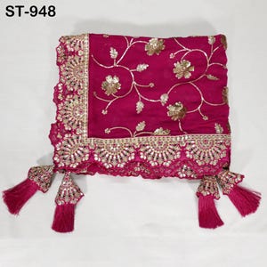 Puede incluir: Un textil magenta con intrincados bordados y adornos dorados. La tela presenta patrones florales y un borde festoneado. Las borlas cuelgan de las esquinas. El texto "ST-948" est&aacute; en la esquina superior izquierda.