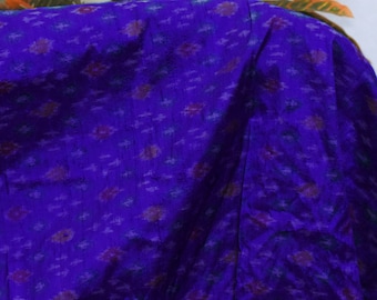 May include: Close-up of a vibrant blue fabric with a subtle pattern of small, colorful floral shapes. The fabric has a slight sheen, suggesting a silk or satin material. The text "Harshita Crafts Pvt Ltd Since 2006" is visible in the bottom right corner.