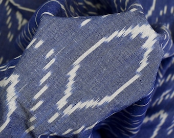 May include: Blue and white ikat fabric with a woven pattern. The fabric is folded and textured.