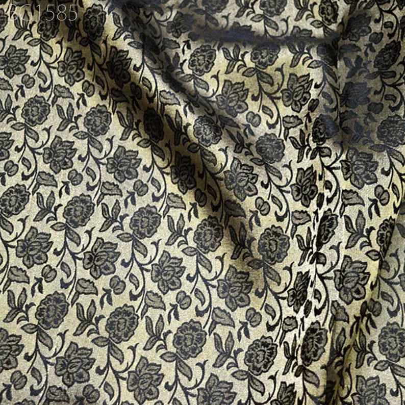 May include: Close-up of a fabric with a black and gold floral pattern. The fabric has a subtle sheen and a soft texture.