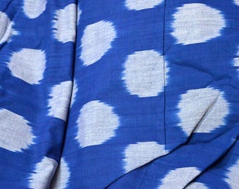 May include: Blue fabric with a white ikat pattern. The fabric has a textured surface and is folded in half.