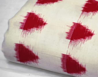 May include: Close-up of a folded fabric with a white background and a repeating pattern of large, red, abstract shapes. The fabric has a soft texture. The text "BCG2250" is in the upper left corner.