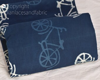 Pode incluir: Tecido de algodão azul com uma estampa de bicicleta branca. O tecido está dobrado ao meio e a estampa é visível em ambos os lados.