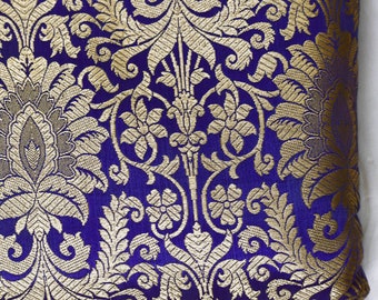 May include: A close-up of a purple fabric with a gold brocade pattern. The fabric has a floral design with intricate details.