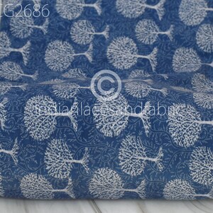 May include: A roll of blue cotton fabric with a white tree pattern. The fabric is folded and has a white tag with the text "BCG2686" on it.