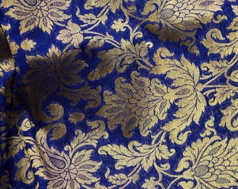 May include: Blue fabric with a gold floral pattern. The fabric has a brocade texture.