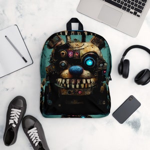 May include: A black backpack with a blue and green background featuring a graphic of a robotic animatronic character with a blue nose and glowing blue eyes.