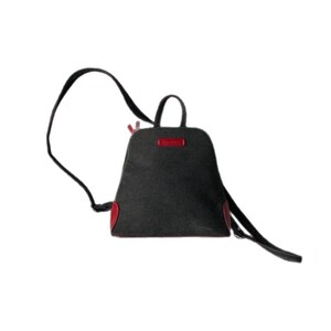 May include: A black backpack with a trapezoidal shape, featuring a top handle and adjustable shoulder straps. The bag includes red accents on the bottom corners and a small red rectangular label on the front centre. The design is simple and functional.