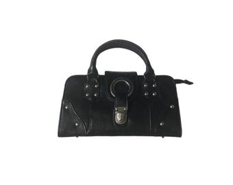 May include: Black handbag with a top handle and silver-tone hardware. The rectangular bag features a flap closure with a metal ring and a clasp. Small silver studs are placed around the edges of the bag.