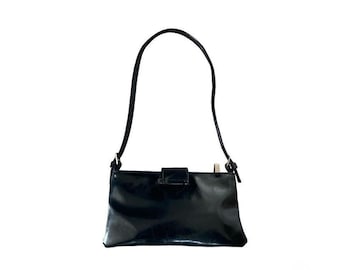 May include: A black patent leather shoulder bag with a single strap. The rectangular bag has a flap closure with a silver-tone metal clasp. The bag is set against a white background.