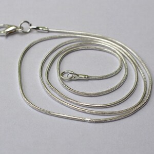 May include: A silver snake chain necklace with a lobster clasp.