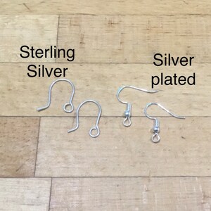 May include: Two pairs of earring hooks, one pair labeled "Sterling Silver" and the other pair labeled "Silver plated".