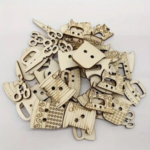 May include: A collection of wooden craft buttons featuring sewing-themed designs, including spools of thread, sewing machines, and scissors. The buttons are unfinished and ready to be painted or decorated.