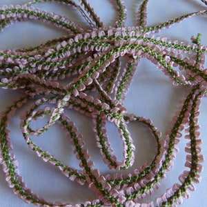 May include: Pink and green ruffled trim with a scalloped edge.