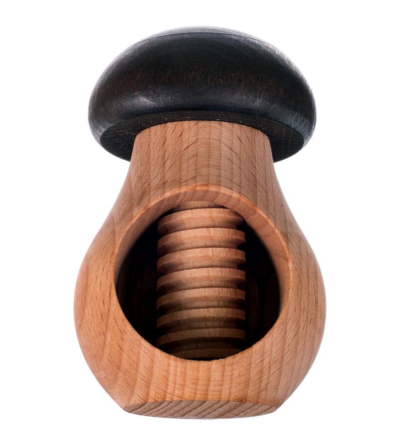 May include: A wooden nutcracker shaped like a mushroom with a dark brown top and a light brown body. The nutcracker has a threaded screw in the center.