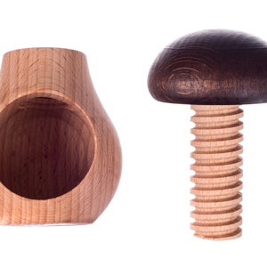 May include: A wooden nutcracker with a brown mushroom-shaped top and a wooden base with a hole in the center.
