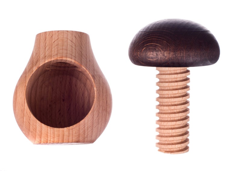 May include: A wooden nutcracker with a brown mushroom-shaped top and a wooden base with a hole in the center.